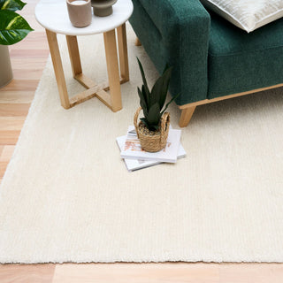 Beige rug styled in a modern living room with furniture.