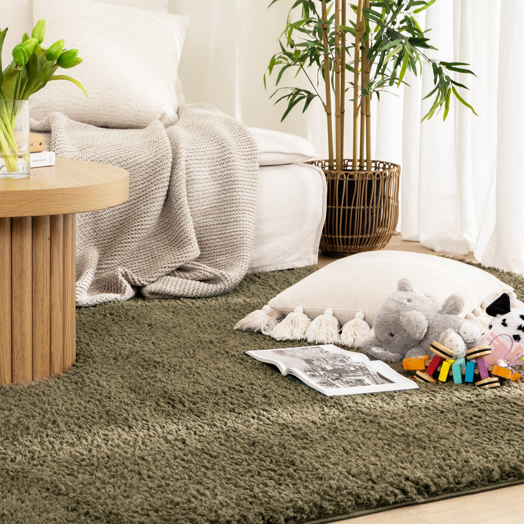 Lune Olive Green Shaggy Rug flat lay in living room with kids toys on top of it.