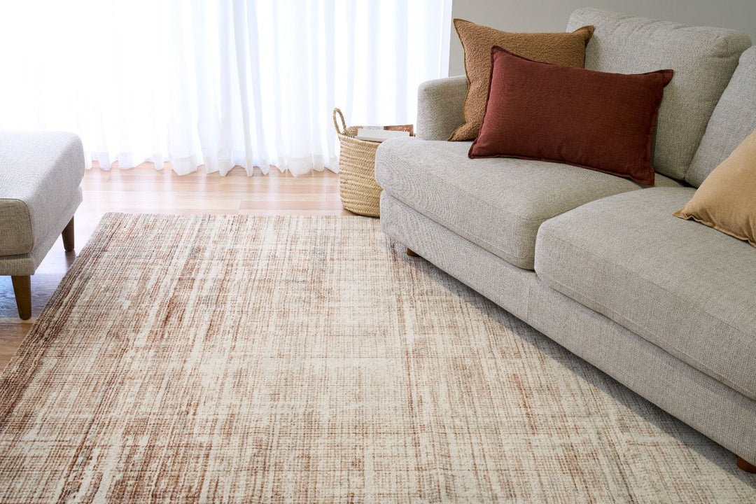 A living room with a brown textured rug under a sofa.