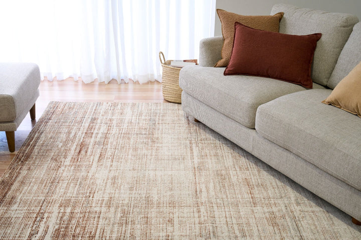 A living room with a brown textured rug under a sofa.