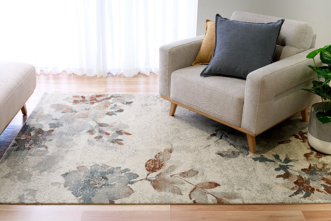 Beige floral rug placed under a modern armchair.