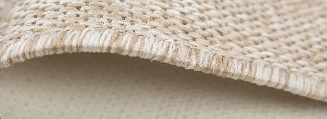 Detailed edge of sand rug showing stitching.