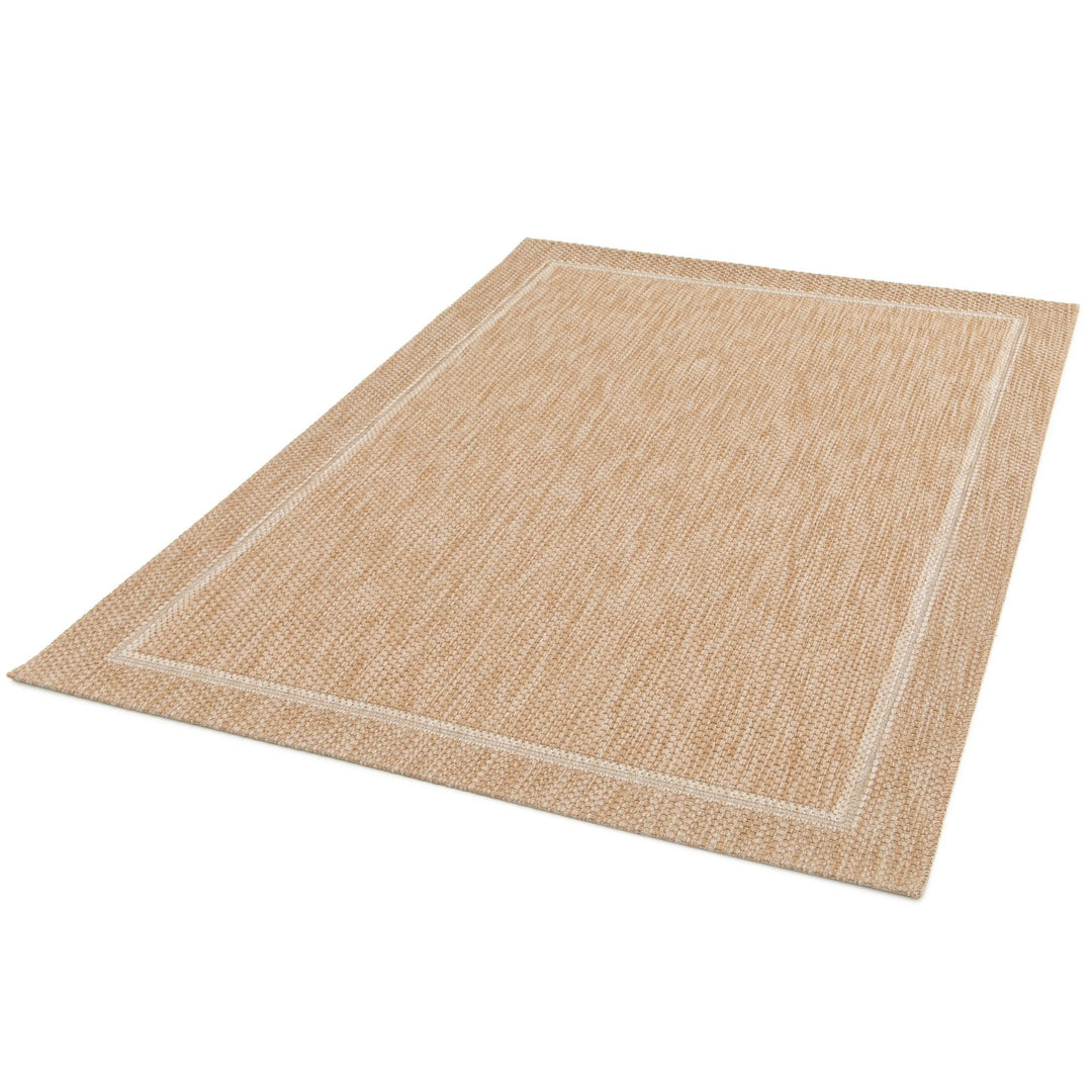 Angled product shot of a rectangular beige woven rug with a subtle double border frame on a white background.