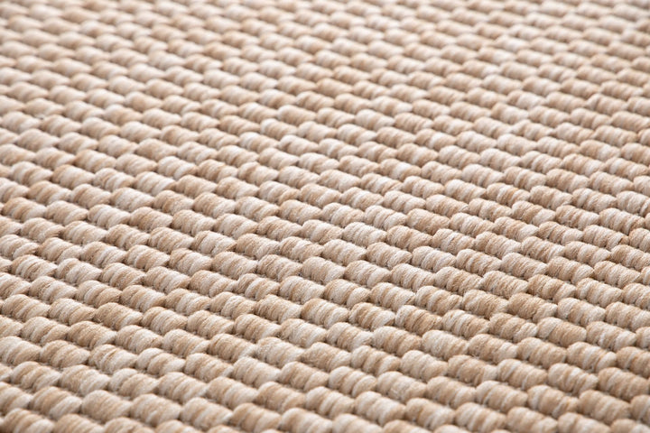 Macro close-up of the Barton indoor/outdoor rug in Sand (41503-070), showing the chunky two-tone basketweave loops in beige and ivory.
