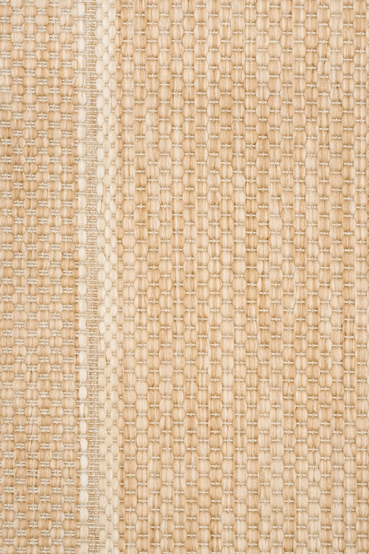 Close-up swatch of a beige Barton woven area rug in sand, showing textured weave and border seam detail.