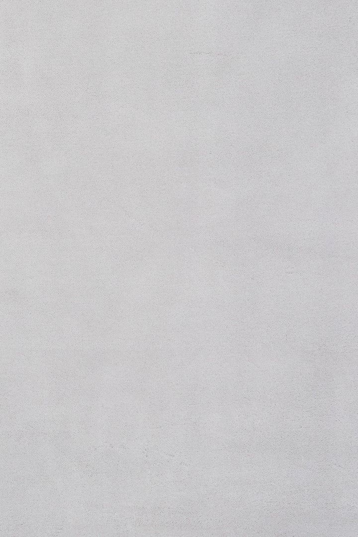 Close-up fabric swatch of a light grey rug showing its smooth texture.