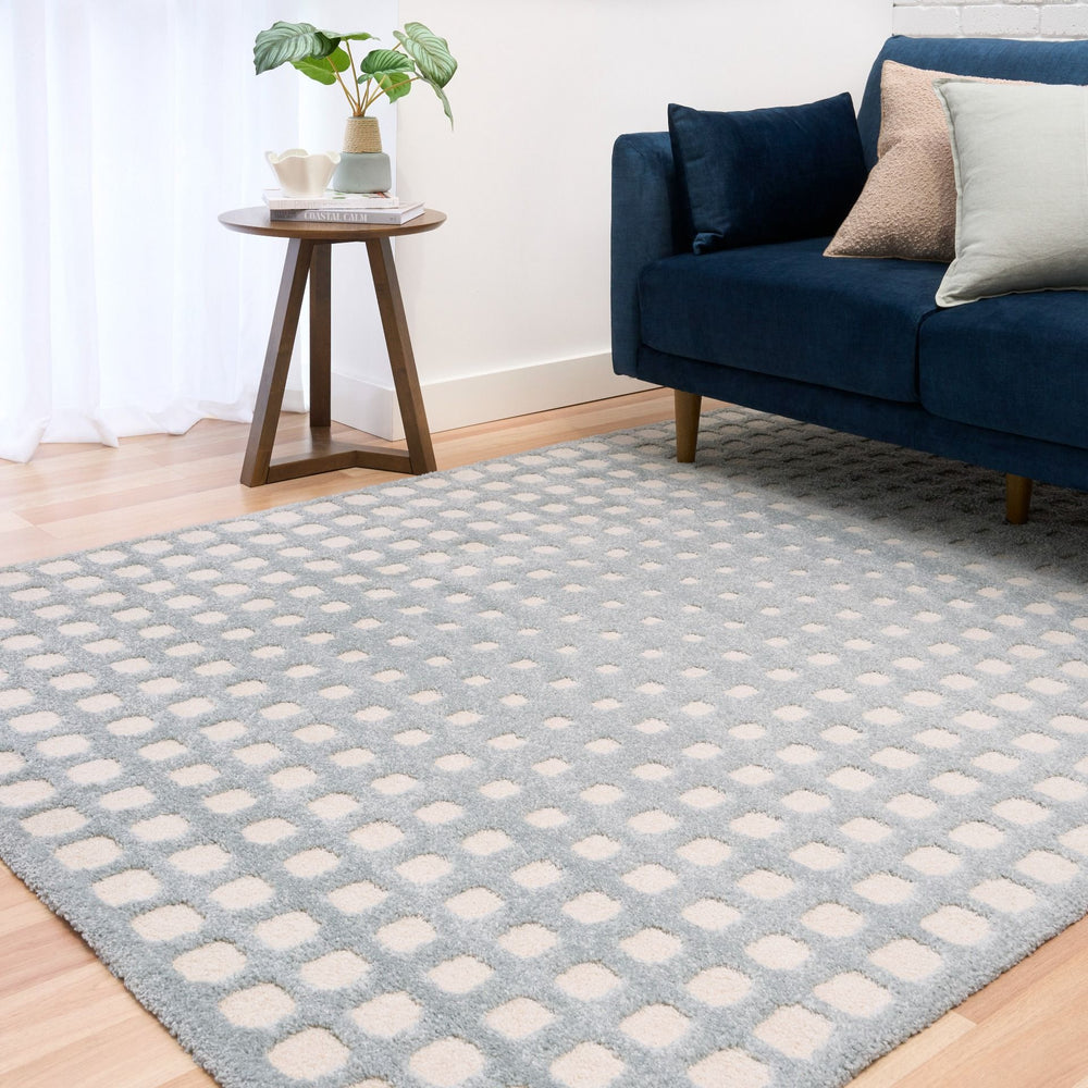 Blue and white rug next to side table and sofa.