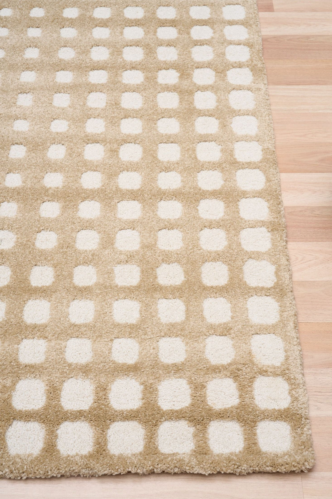 Close-up of beige rug with white square dots.