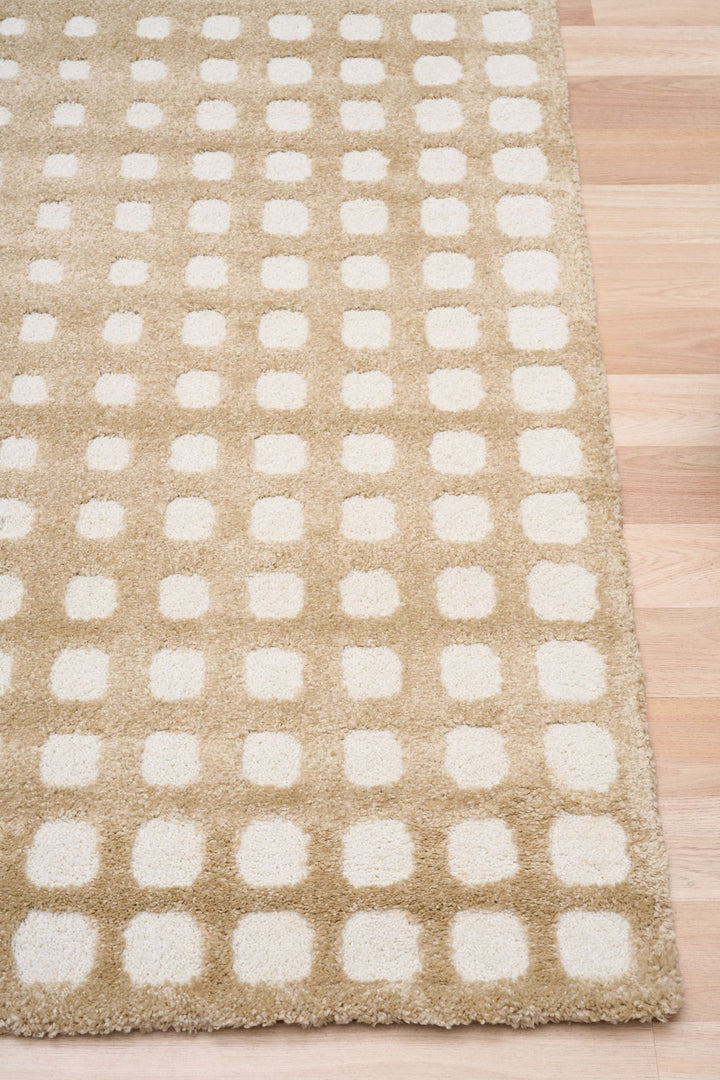 Close-up of beige rug with white square dots.