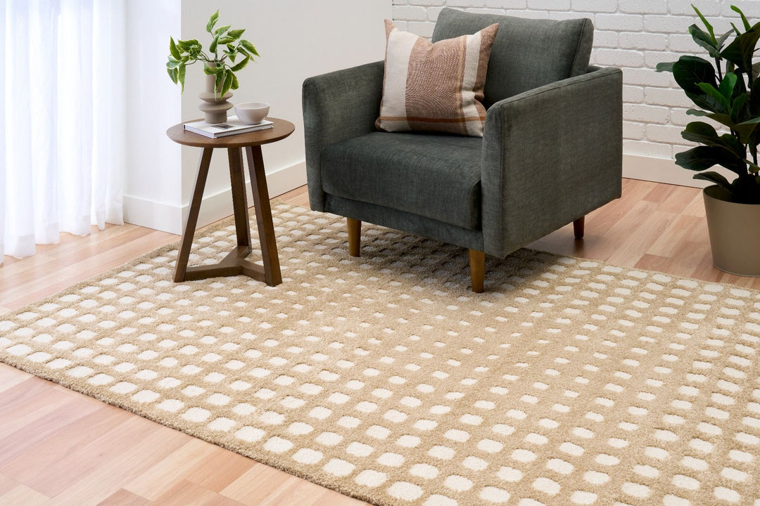 Beige rug styled in living room with armchair.