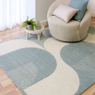 Rug styled in living room with chair and cushion.