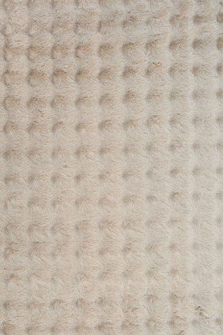 Close-up of light beige textured fluffy rug fabric.