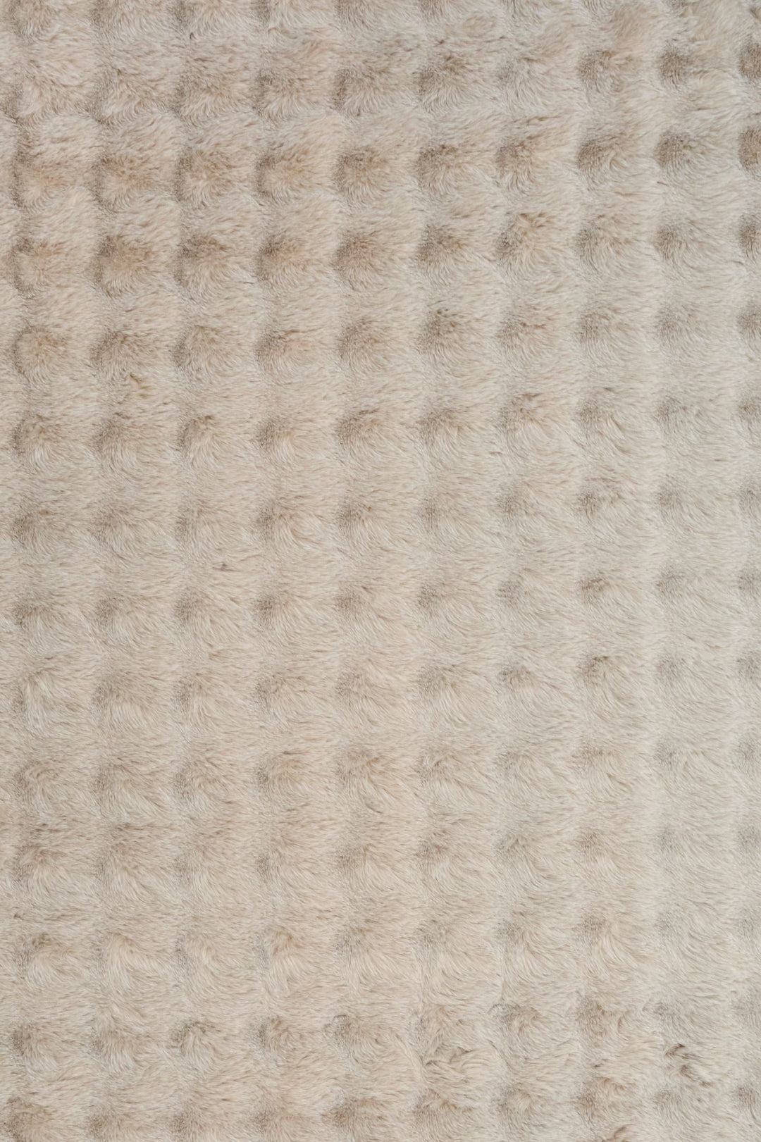 Close-up of light beige textured fluffy rug fabric.