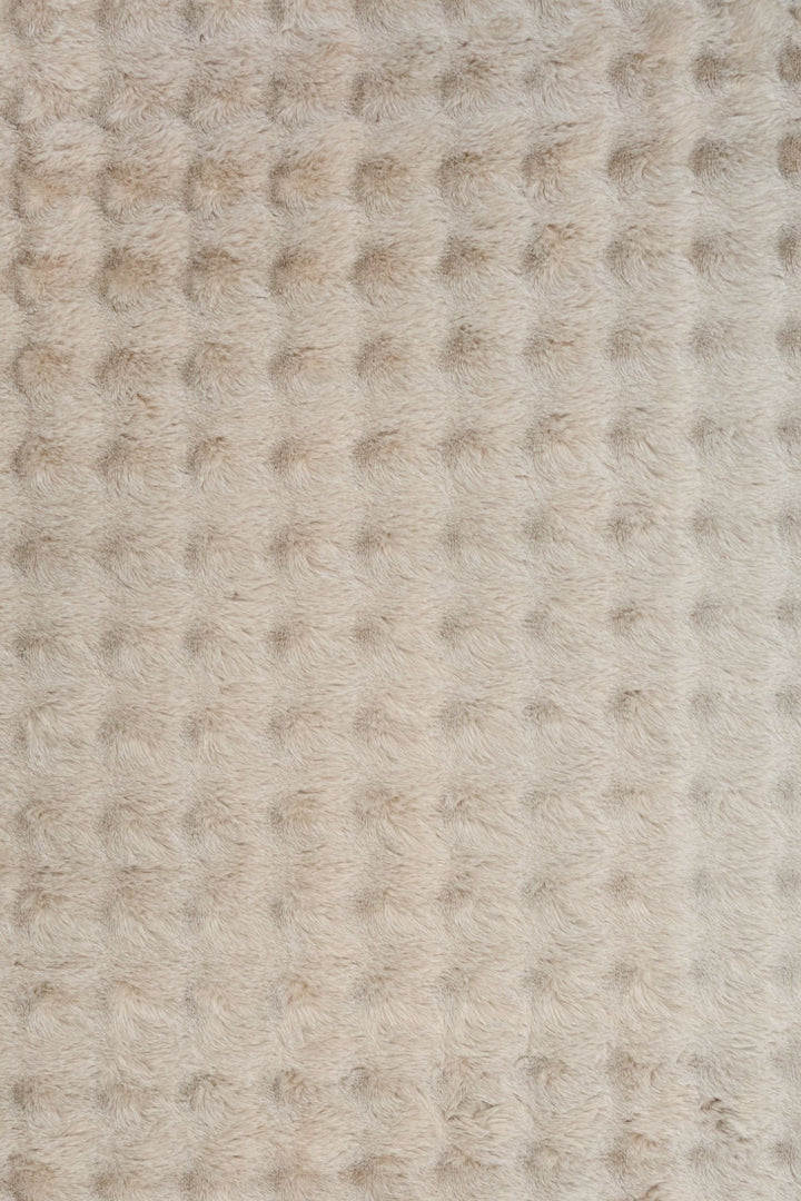Close-up of light beige textured fluffy rug fabric.