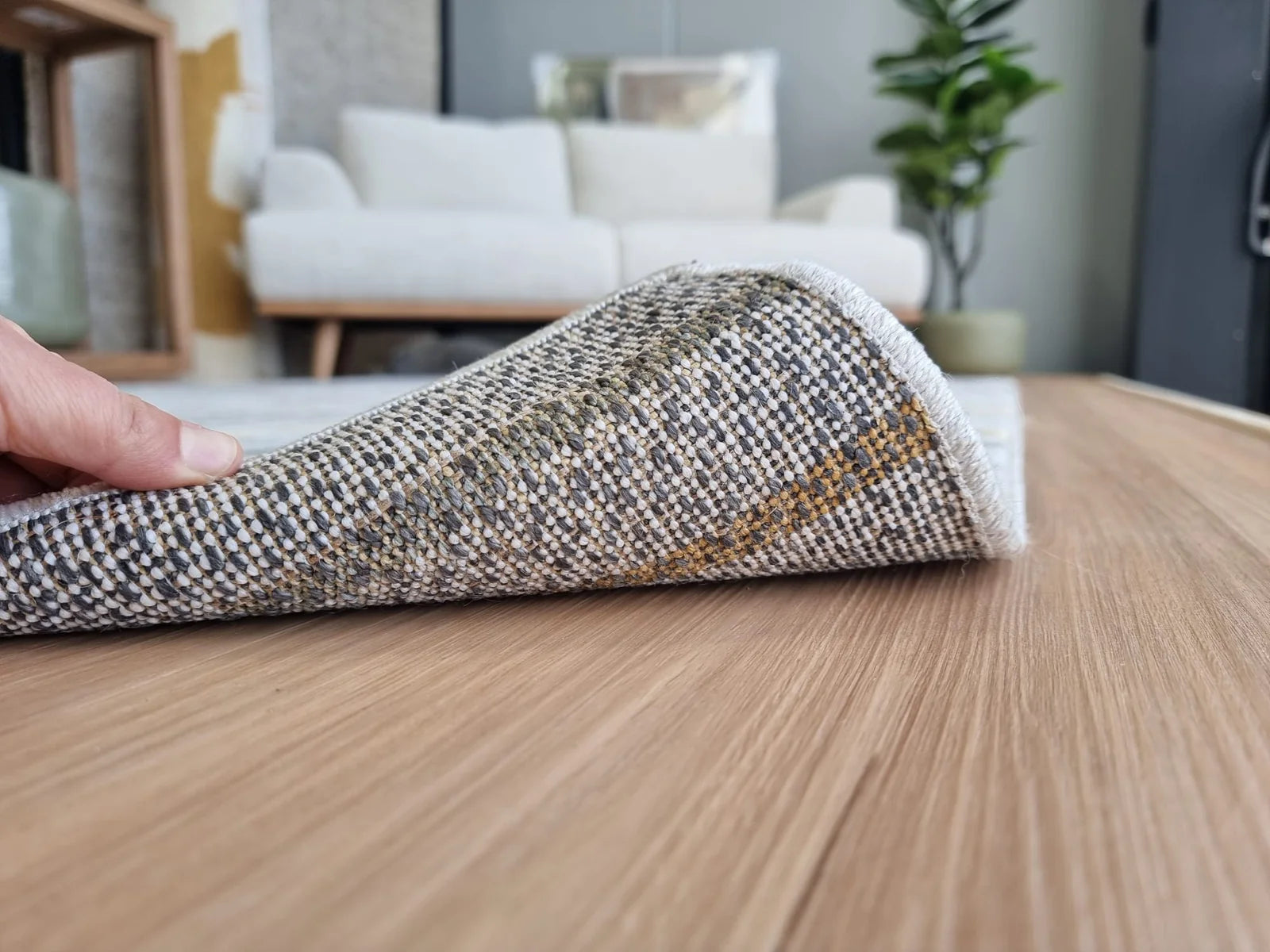 Cotton action rug backing lifted on timber flooring, showing the woven backing construction