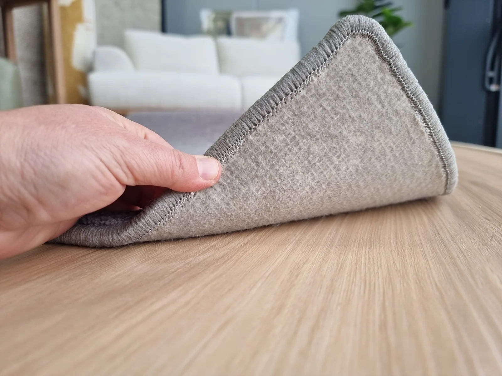 Felt rug backing lifted on timber flooring, showing the soft cushioned underside