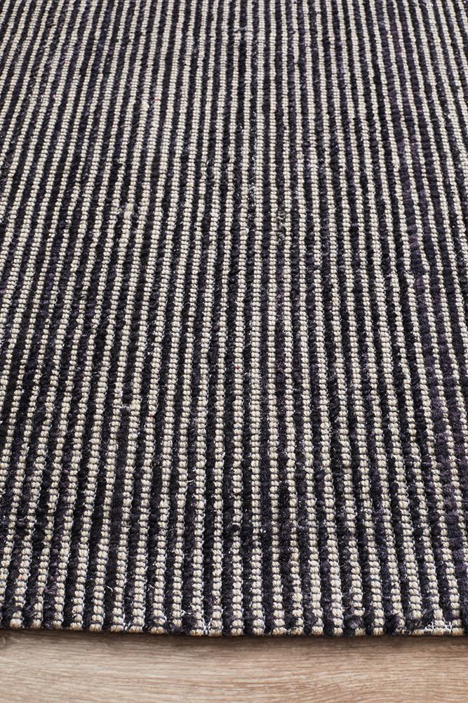 Allure Black rug in minimalist space with dramatic black and metallic accents