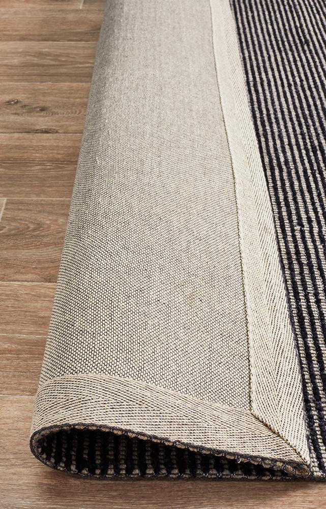 Allure Black cotton rayon rug on hardwood floor showing natural cotton fiber backing 