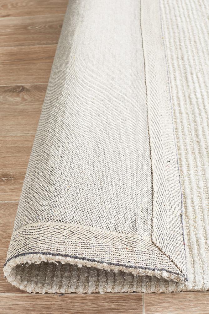 Allure Ivory cotton rayon area rug with natural cotton backing, on a hardwood floor.